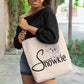 The Snowkie Tote Bag with a woman showing the bag